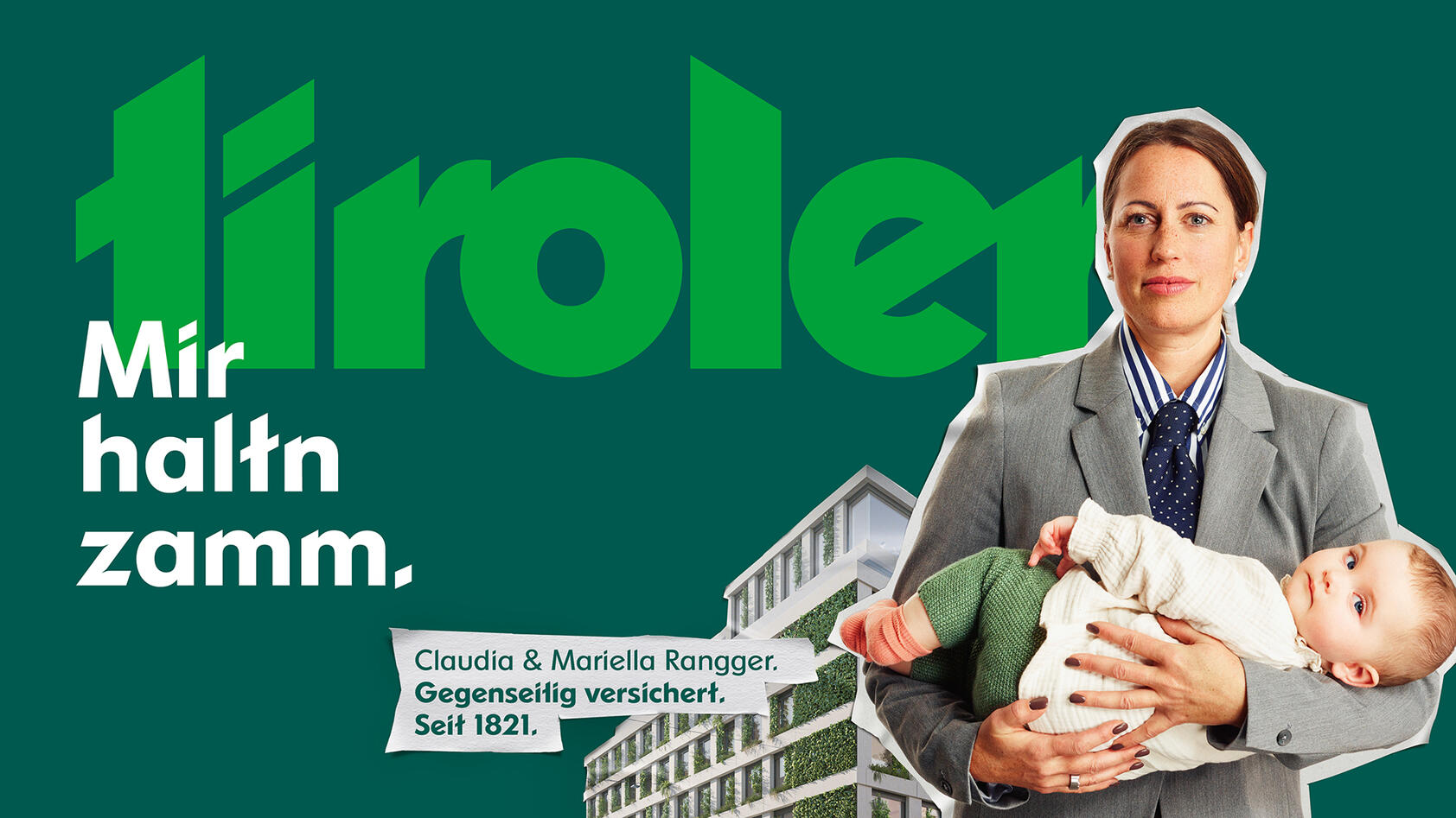 Frau in grauem Anzug mit Baby auf dem Arm